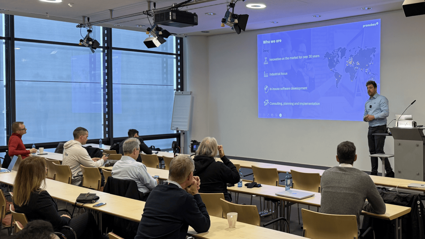 Präsentation bei einem Workshop mit mehreren Teilnehmern und einem Referenten an der Tafel.