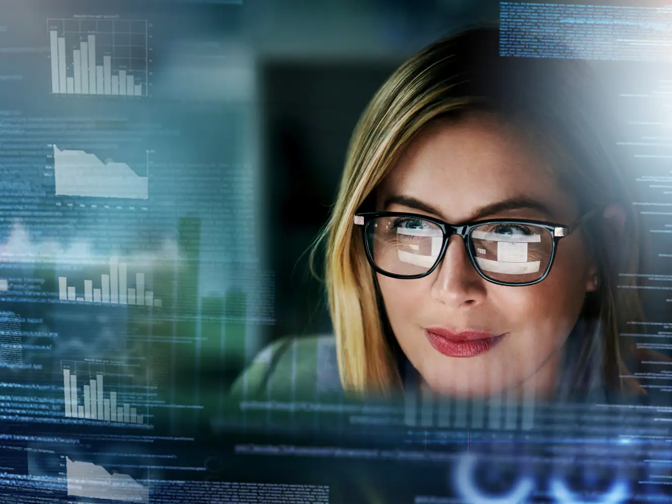 Frau mit Brille analysiert digitale Industrie-Daten auf einem Bildschirm.