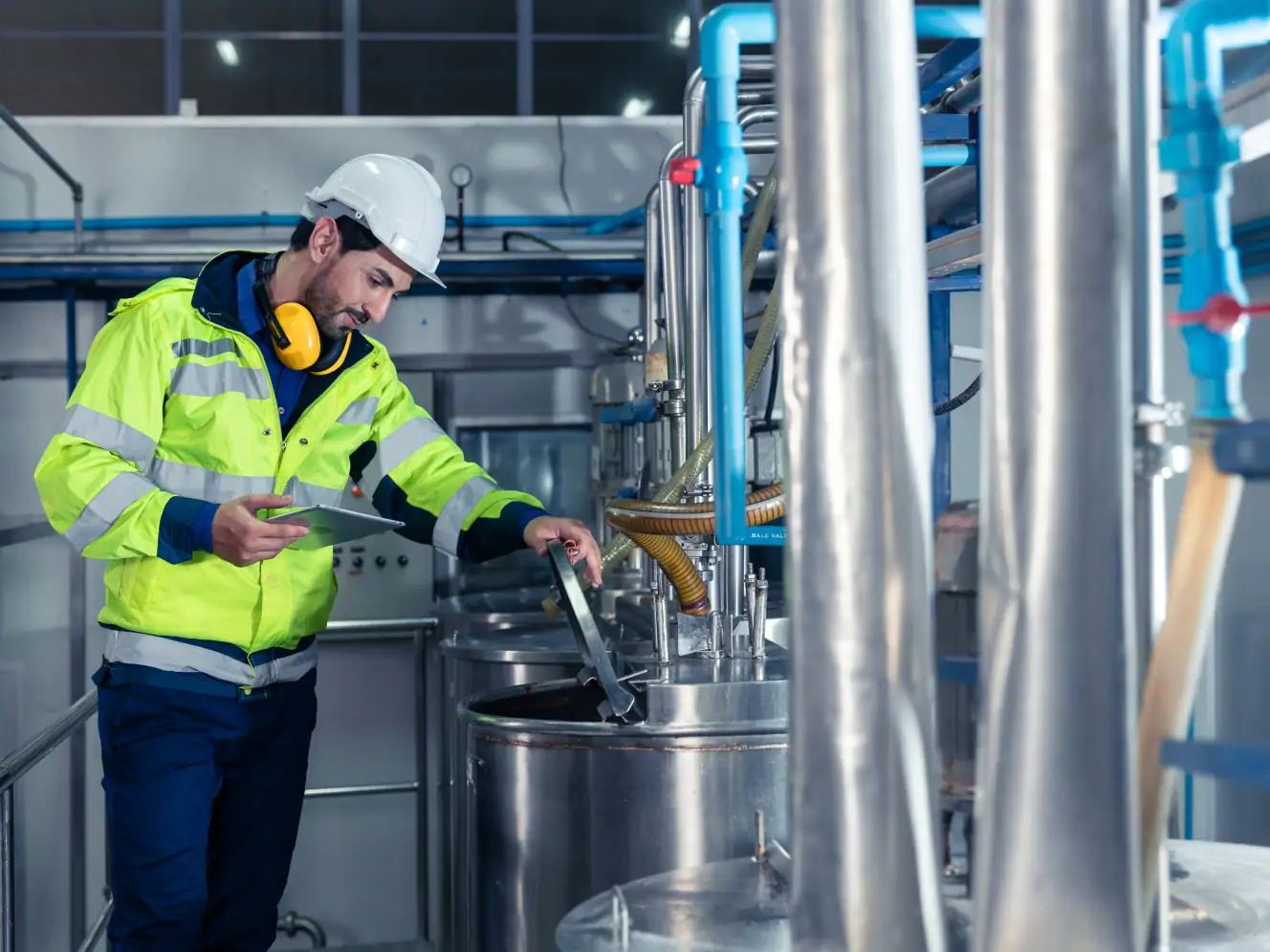 Ingenieur überprüft Industrieanlage mit moderner Software.