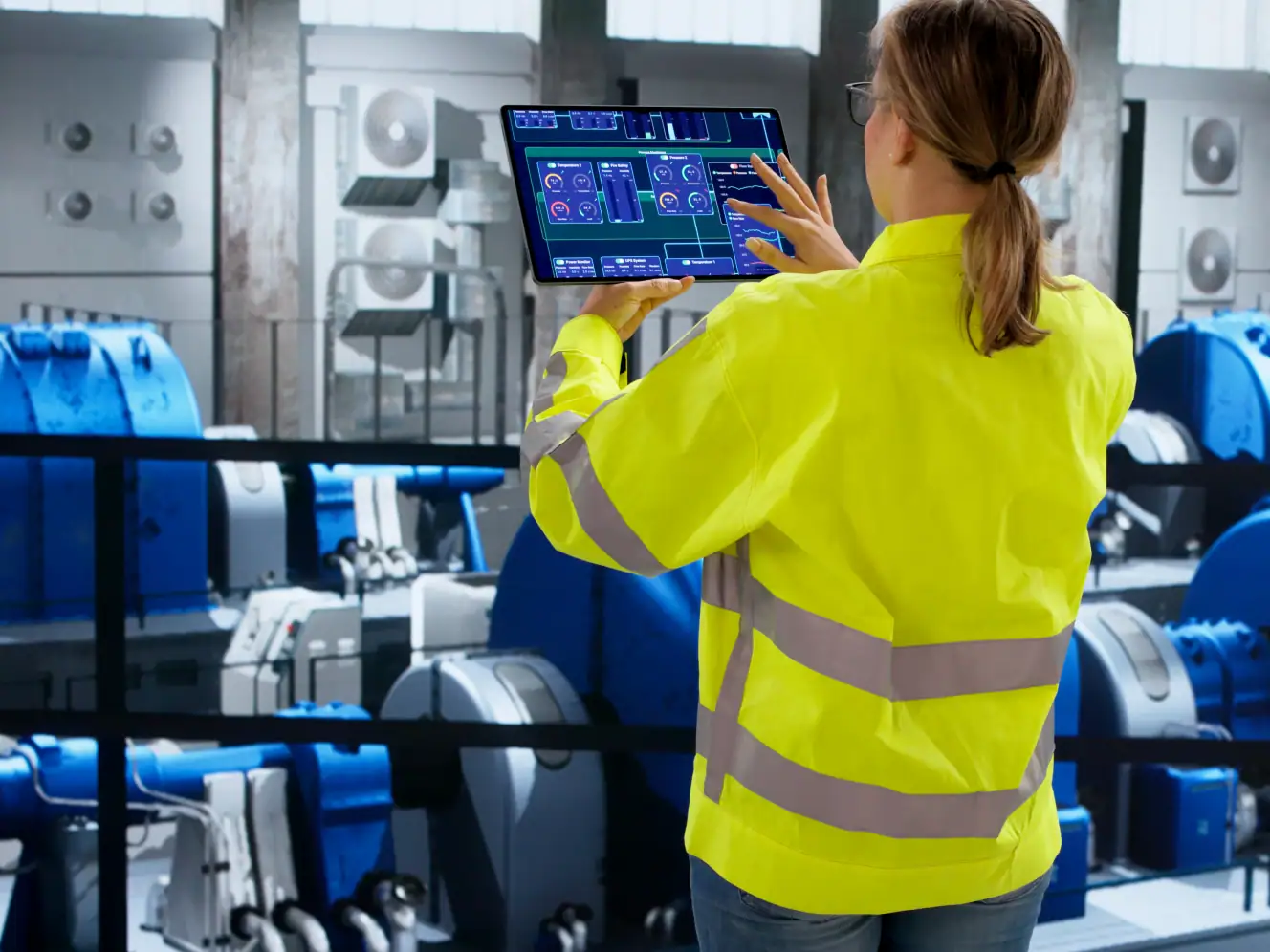 Mitarbeiterin überwacht Industrieanlagen mit digitaler Steuerung.